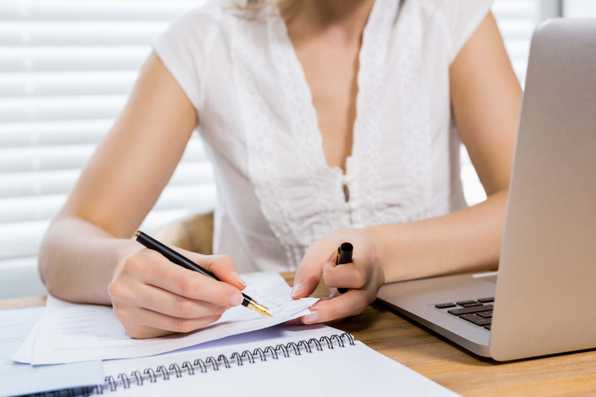 Mid section of woman writing on paper at home